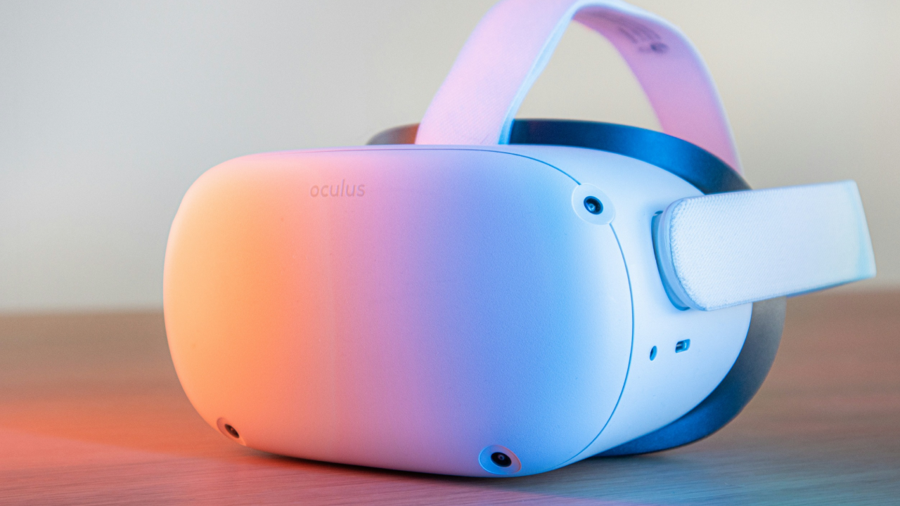 Close-up white VR headset on wooden surface, with colourful light shining on it.